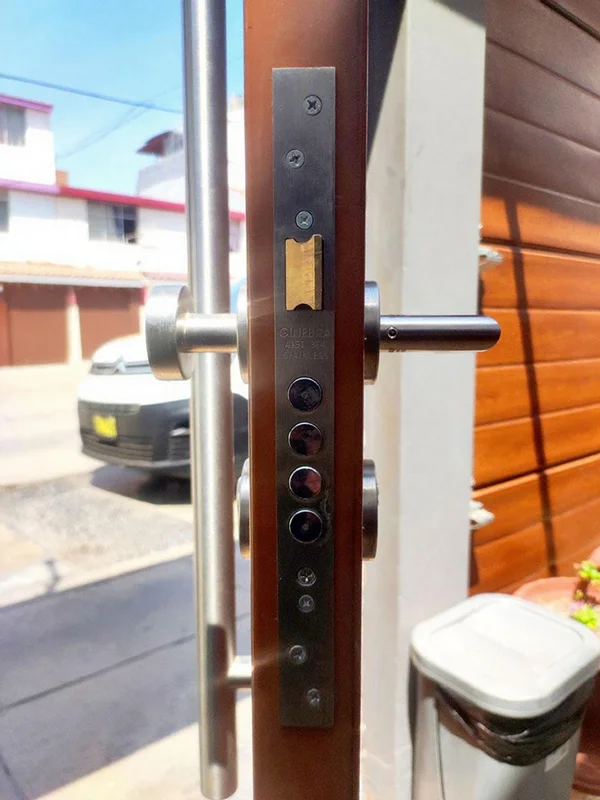 Detalle cerradura seguridad multipunto puerta acero instalada en residencia.