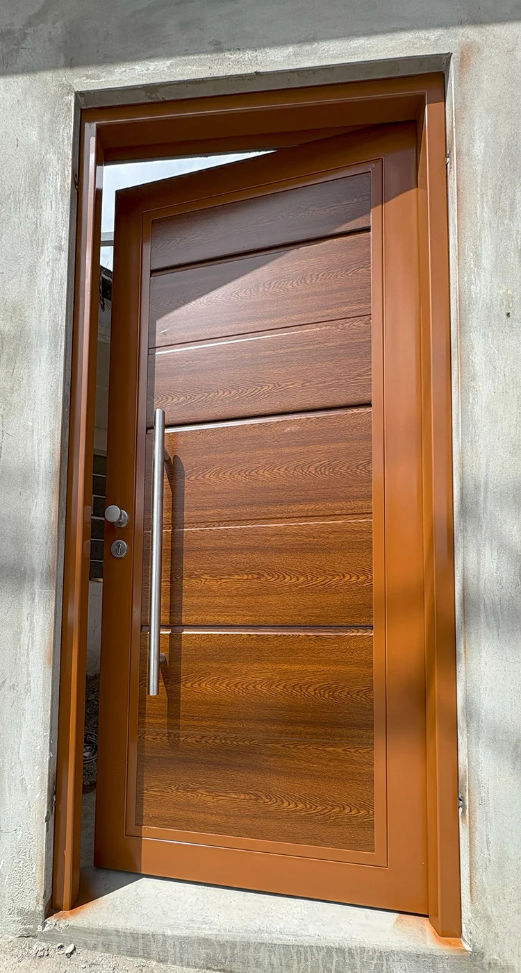 Puerta peatonal de seguridad haciendo juego con portón de garaje levadizo, ambos con acabado tipo madera.