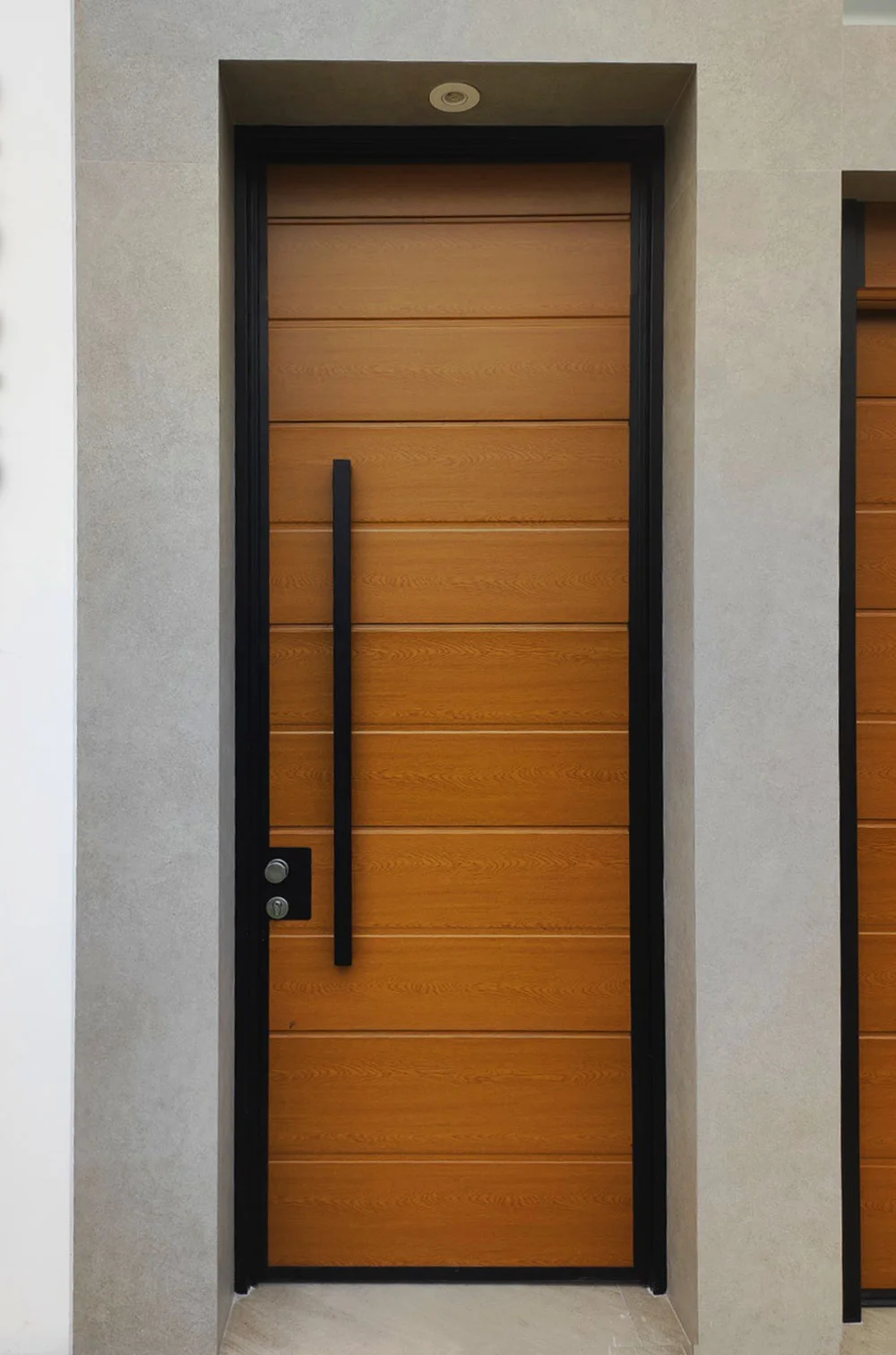 Puertas principales modernas con acabado de madera y marco negro.